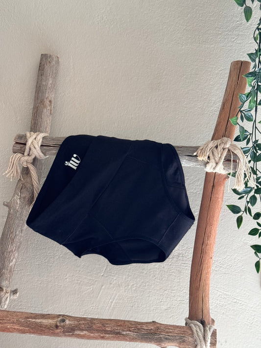 Culotte menstruelle posée sur une échelle en bois et une lierre qui décore le coté de l'image.