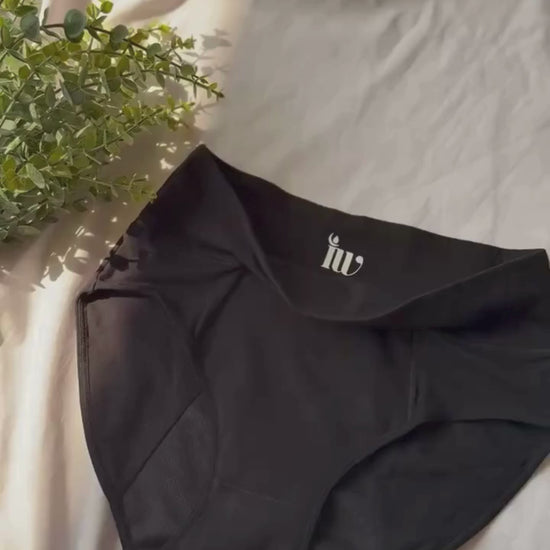 Vidéo zoomant lentement sur le modèle taille haute, présenté sur un drap blanc et décoré d'une branche.