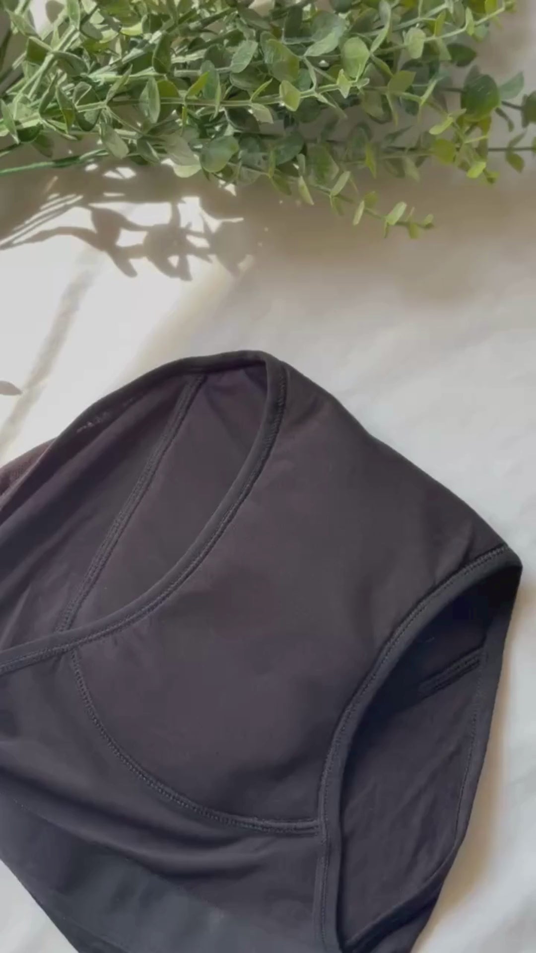 Vidéo zoomant sur le gousset de la culotte menstruelle modèle standard, avec des branches décorant le haut de la vidéo.